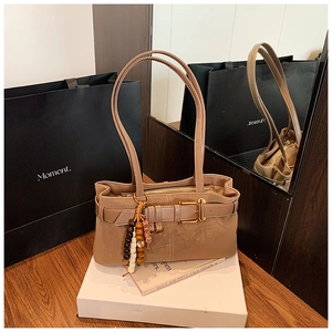 Détail du sac bandoulière vintage kaki avec pendentif en perles ethniques et boucle métal