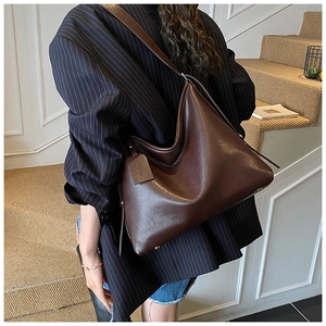 Detailed view of deep brown large-capacity tote bag with sleek shoulder strap and bag charm