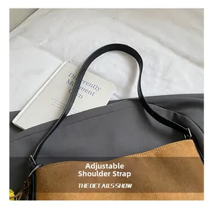 Detail of adjustable black strap and silver buckle on a brown suede bucket shoulder bag