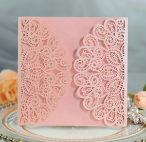 Detail of pink laser-cut wedding invitation with intricate lace floral pattern