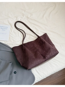 Détail d'un grand sac cabas en daim marron au design minimaliste et longues bandoulières