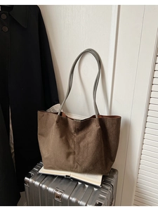 Détail du grand sac cabas en daim marron foncé avec couture verticale et fines anses grises