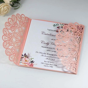 Macro detail of laser-cut floral invitation with pink hollow lace and white card