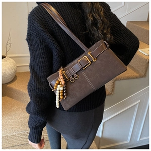 Détail du sac à bandoulière vintage en similicuir marron foncé avec boucle et perles