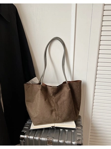 Détail d'un grand sac cabas en daim marron foncé avec poignées grises en décor lifestyle