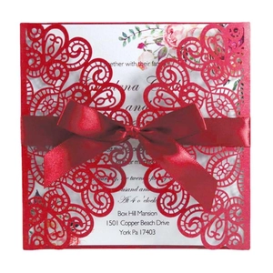 Red laser-cut wedding invitation featuring a peacock lace pattern and elegant satin ribbon bow