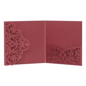 Macro view of laser-cut lace floral pattern on deep red wedding invitation sleeve