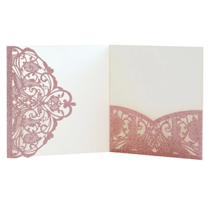 Detail of laser-cut rose gold glitter wedding invitation showing intricate floral patterns