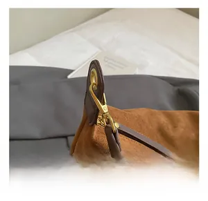 Détail du crochet en métal doré et des coutures lisses sur sac cabas en daim brun