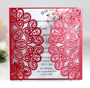 Macro detail of red laser-cut wedding invitation with elegant floral inner card
