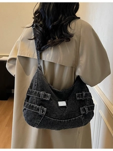 Large black denim hobo bag with silver metal buckles shown on model for daily street style