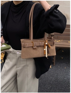 Détail du sac porté épaule vintage marron avec boucle de ceinture et pendentif en bois