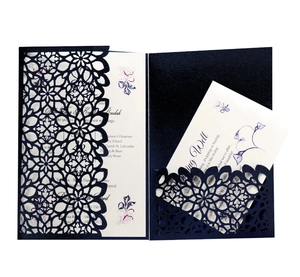 Navy blue laser cut wedding invitation with intricate floral hollow design and white insert