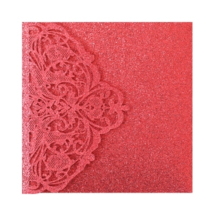 Close-up of red glitter laser-cut lace and heart patterns on wedding invitation cover