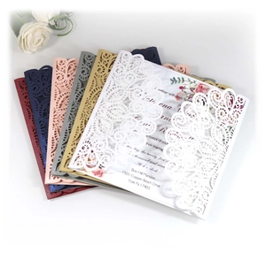 Close-up of laser-cut peacock lace pattern on multicolor wedding invitation cards