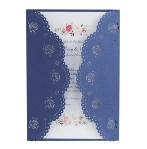 Detail of laser cut navy blue wedding invitation with intricate hollow rose pattern
