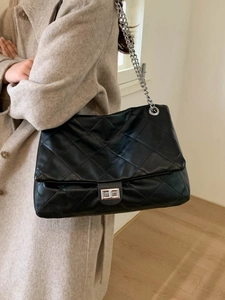 Chic black quilted tote bag with silver chain strap and metal lock for elegant daily commute