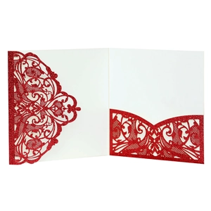 Detail of red glitter laser-cut wedding invitation with intricate floral lace pattern