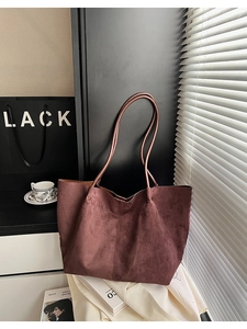 Grand sac cabas bordeaux en daim avec fines bandoulières dans un décor épuré et minimaliste