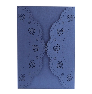 Detailed laser-cut rose patterns on a dark blue pearlescent paper invitation cover