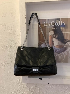 Quilted black leather tote bag with silver chain strap and classic diamond pattern