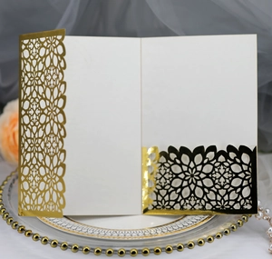 Detail of luxury laser-cut wedding invitation with gold mandala pattern and white insert