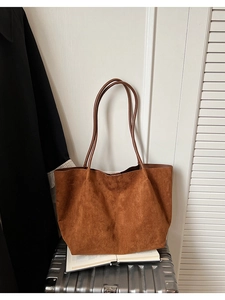 Vue détaillée du sac cabas en daim marron avec texture fine et anses en cuir lisse