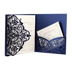 Close-up of laser-cut floral patterns on dark blue pearlescent wedding invitations