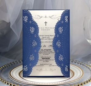 Detail of laser-cut rose hollow wedding invitation in navy blue glitter with silver insert