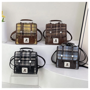 Detailed display of four color plaid backpacks with bear patches in a studio setting