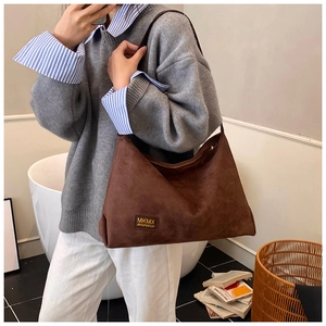 Détail du sac cabas en daim marron avec étiquette MKMX montrant la texture douce du tissu