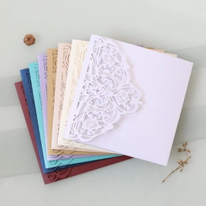 Close-up of laser-cut lace wedding invitation covers in various vibrant color options