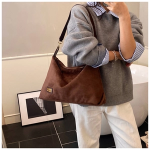 Détail du grand sac à épaule en daim marron foncé avec bandoulière en cuir MKMX