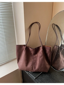 Détail du grand sac cabas en daim marron foncé avec de fines bretelles pour femmes
