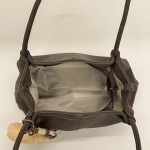 Detailed interior of dark brown matte shoulder bag showing spacious gray lining and zipper