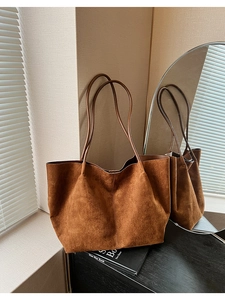 Détail du grand sac cabas en daim marron caramel avec texture souple et bandoulière