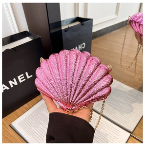 Detailed close-up of metallic pink shell-shaped evening bag with golden chain strap