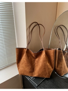 Vue détaillée du grand sac cabas en daim marron foncé avec fines anses en cuir souple