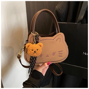 Dettaglio della borsa gatto marrone con ricamo e ciondolo a forma di orsetto di peluche