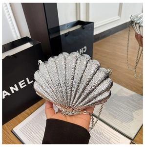 Close-up of a silver shell-shaped evening bag with a metallic finish and fine chain strap