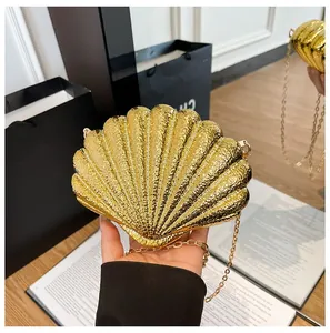 Detail of golden shell-shaped evening clutch with 3D textures and gold chain strap