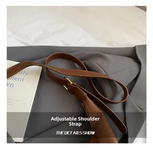 Detailansicht der braunen Ledertasche mit verstellbarem Schultergurt und Goldschnalle