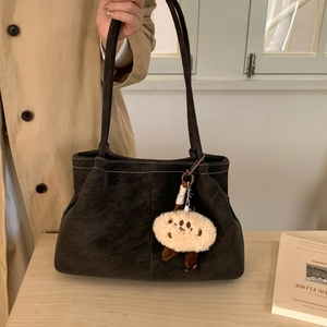 Detail of matte dark grey tote bag with contrast stitching and plush cookie charm