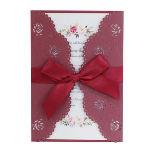 Elegant burgundy laser-cut rose wedding invitation card with red satin ribbon bow