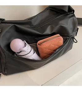 Detailed view of the front zipper pocket on a black multi-layer crossbody bag