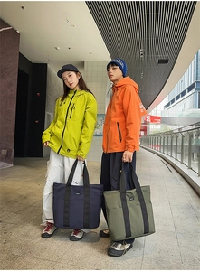 Detail of high-capacity nylon tote bags in navy and green for outdoor commute