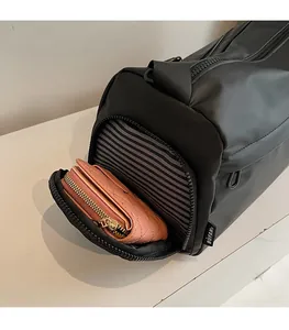 Detailed side pocket of black travel bag with pink wallet showing storage capacity