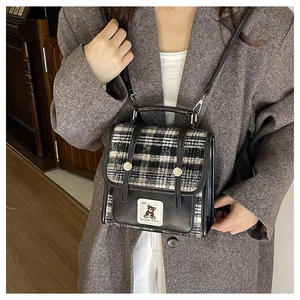British style plaid crossbody bag with embroidered bear detail shown on a brown blazer