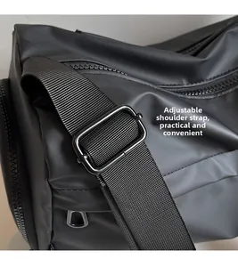 Detail of adjustable woven shoulder strap with metal buckle on black crossbody bag