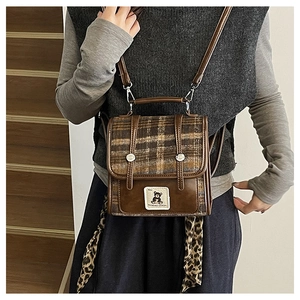Détail d'un cabas en laine à carreaux avec finitions en cuir marron et foulard léopard